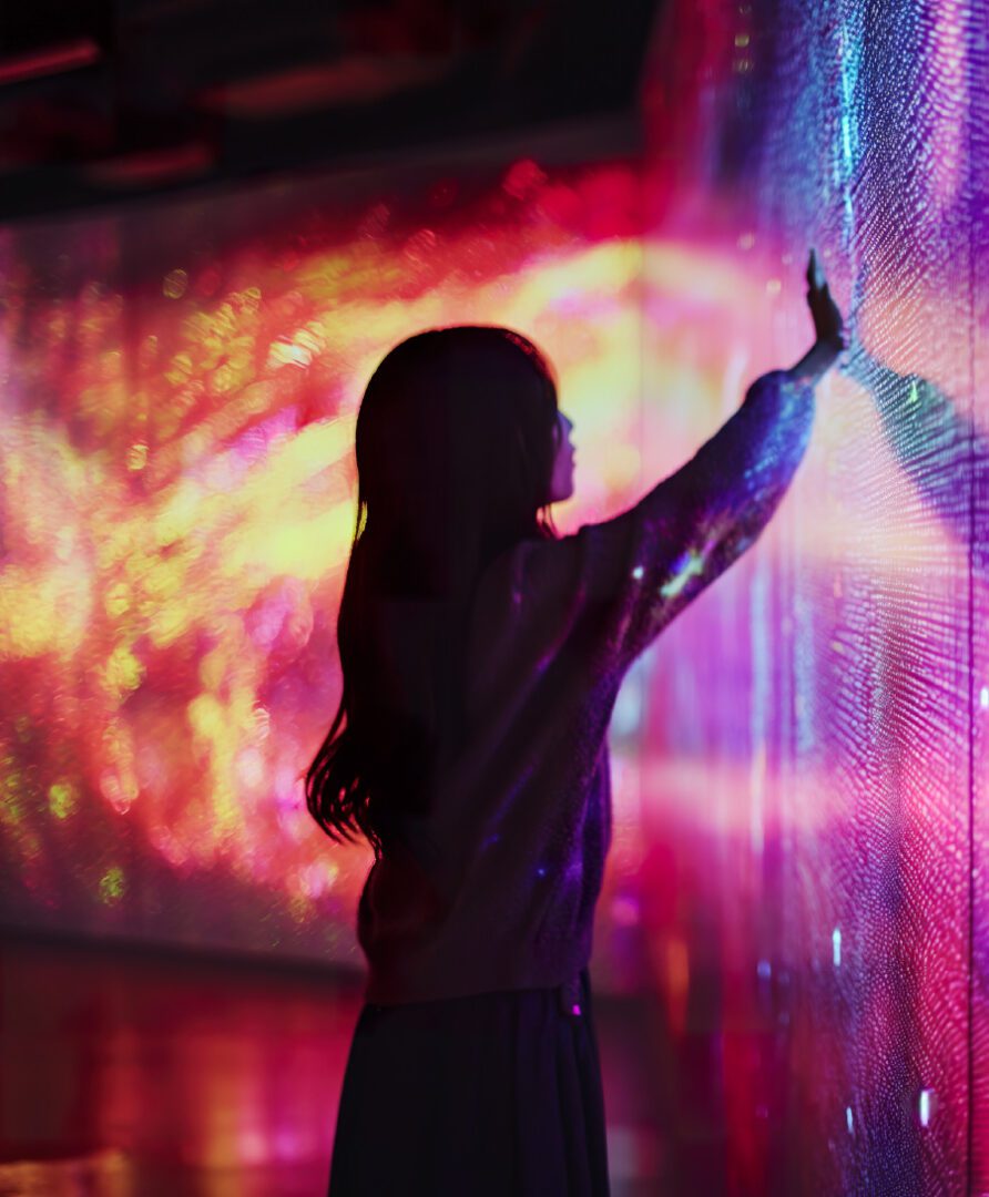 photo of woman interacting with LED wall, link to digital signage services page